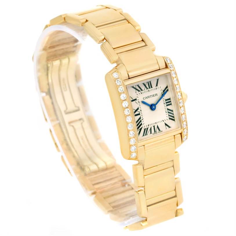 The image shows a Cartier Tank Francaise WE1001R8 Women's Yellow Gold Silver Dial WE1001R8 Women's Yellow Gold Silver Dial watch angled slightly from the front, displaying its gold bracelet, diamond-set bezel, and rectangular dial.