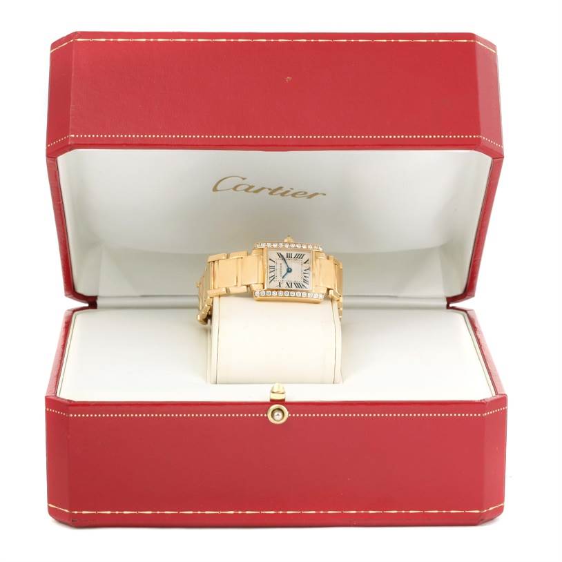 The Cartier Tank Française watch is displayed front-facing with a metal band inside a red Cartier box.