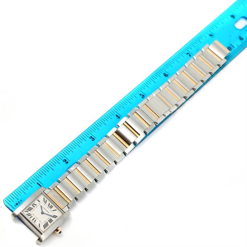 The image shows a Tank Francaise model by Cartier laid flat with a blue ruler next to it for measurement.