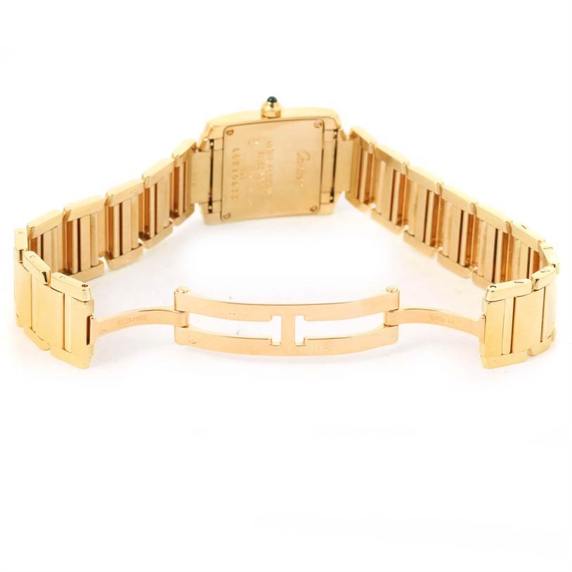This image shows the back side and open clasp of a Cartier Tank Française watch, featuring its gold metal bracelet and case back.