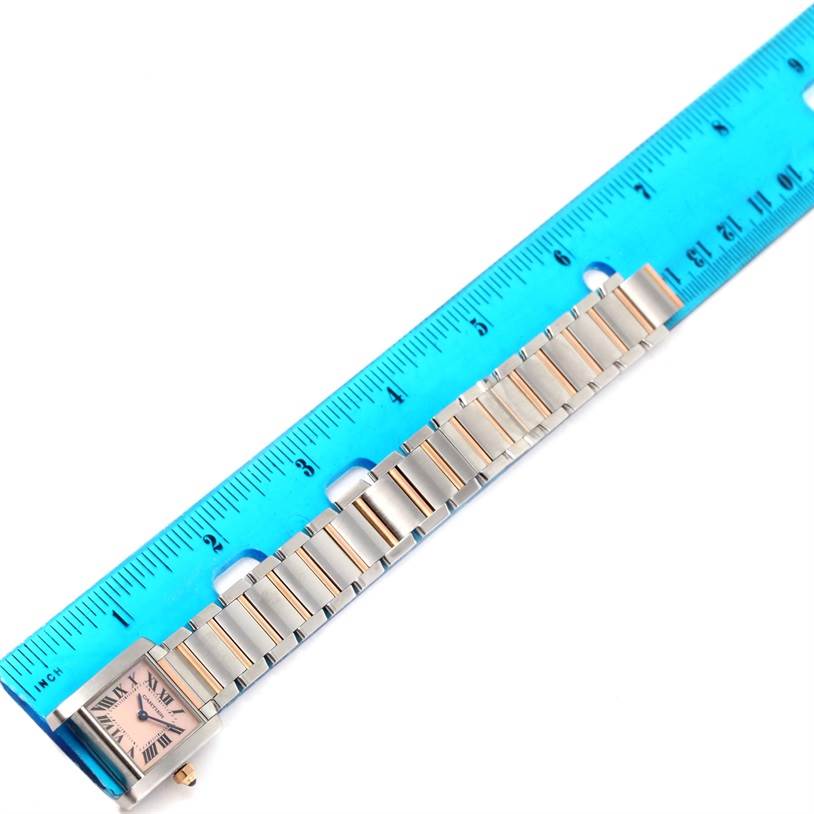 The Cartier Tank Francaise W51027Q4 Women's Steel and Gold (two tone) Mother of Pearl Dial W51027Q4 Women's Steel and Gold (two tone) Mother of Pearl Dial watch is shown from a top-down angle, displaying the face and the metal bracelet next to a ruler.