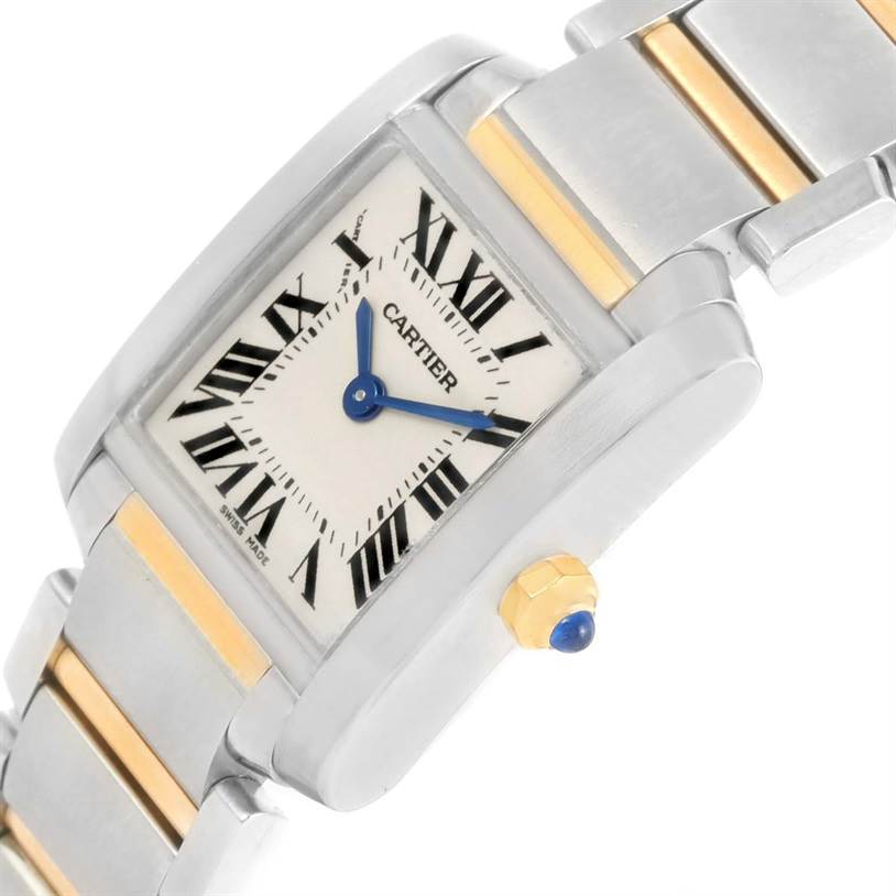 The Cartier Tank Française watch is shown at an angle, highlighting its square face, Roman numerals, blue hands, and metal band.