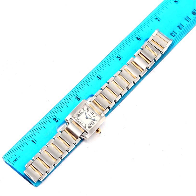 The image shows a Cartier Tank Francaise W51007Q4 Women's Steel and Gold (two tone) Silver Dial W51007Q4 Women's Steel and Gold (two tone) Silver Dial watch laid flat next to a blue ruler for scale, displaying the entire band and face.