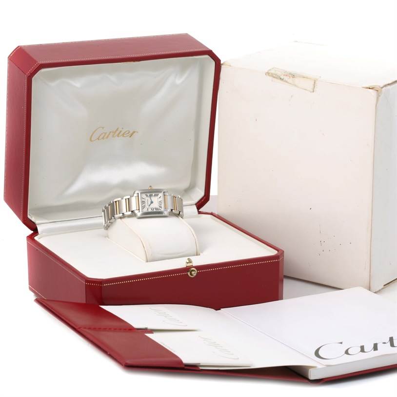 The Cartier Tank Française watch is displayed in its open red box with accompanying booklets and outer packaging visible.
