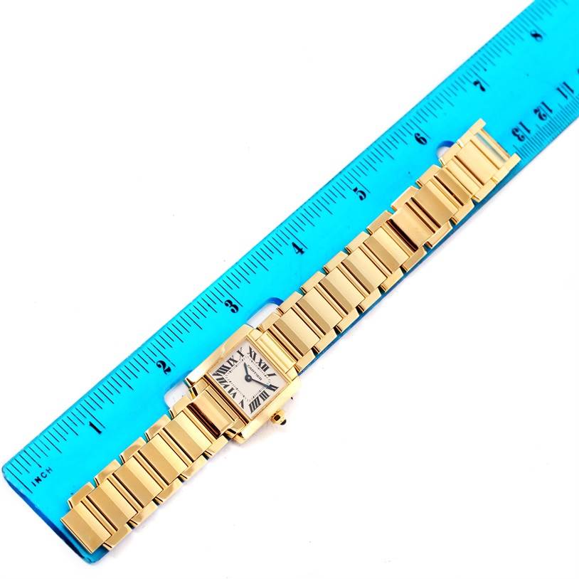 The image shows a top-down view of a Cartier Tank Francaise W50002N2 Women's Yellow Gold Silver Dial W50002N2 Women's Yellow Gold Silver Dial watch laid next to a ruler.