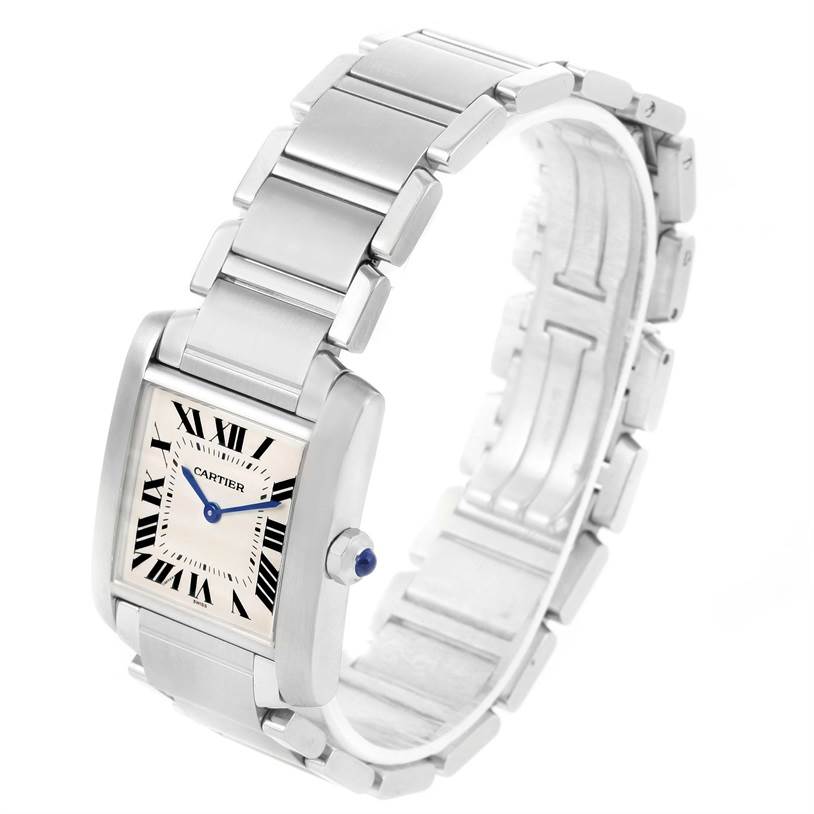 The image shows a Cartier Tank Francaise WSTA0005 Women's Stainless Steel Silver Dial WSTA0005 Women's Stainless Steel Silver Dial watch at a three-quarter angle, highlighting its face, bracelet, and blue cabochon crown.