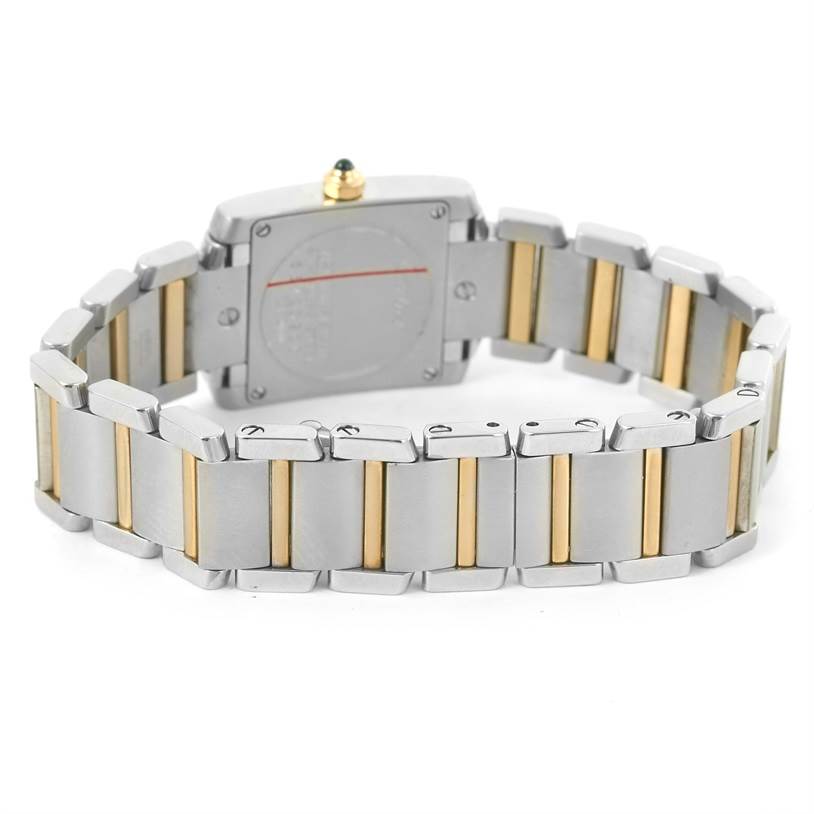 The image shows the back of a Cartier Tank Française watch, highlighting its metal bracelet with gold accents.