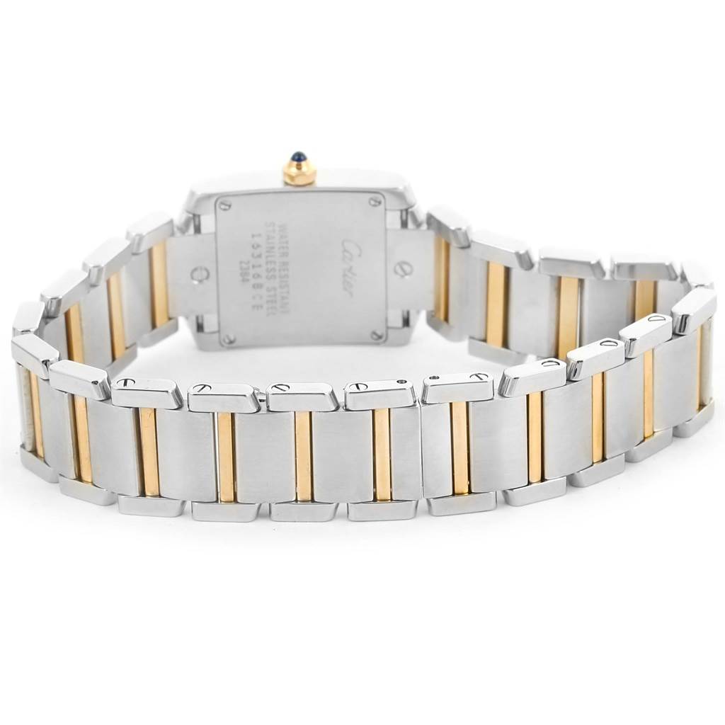The image shows the back of the Cartier Tank Française watch, emphasizing its stainless steel and gold bracelet.