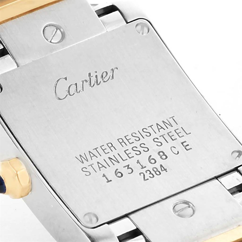 The image shows the back case of a Cartier Tank Française watch, highlighting its screws and engraved details.