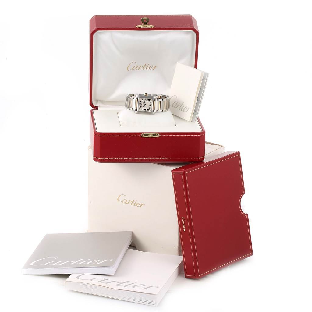 The Cartier Tank Francaise W51012Q4 Women's Steel and Gold (two tone) Silver Dial W51012Q4 Women's Steel and Gold (two tone) Silver Dial watch is displayed in an open red box, alongside manuals and packaging.