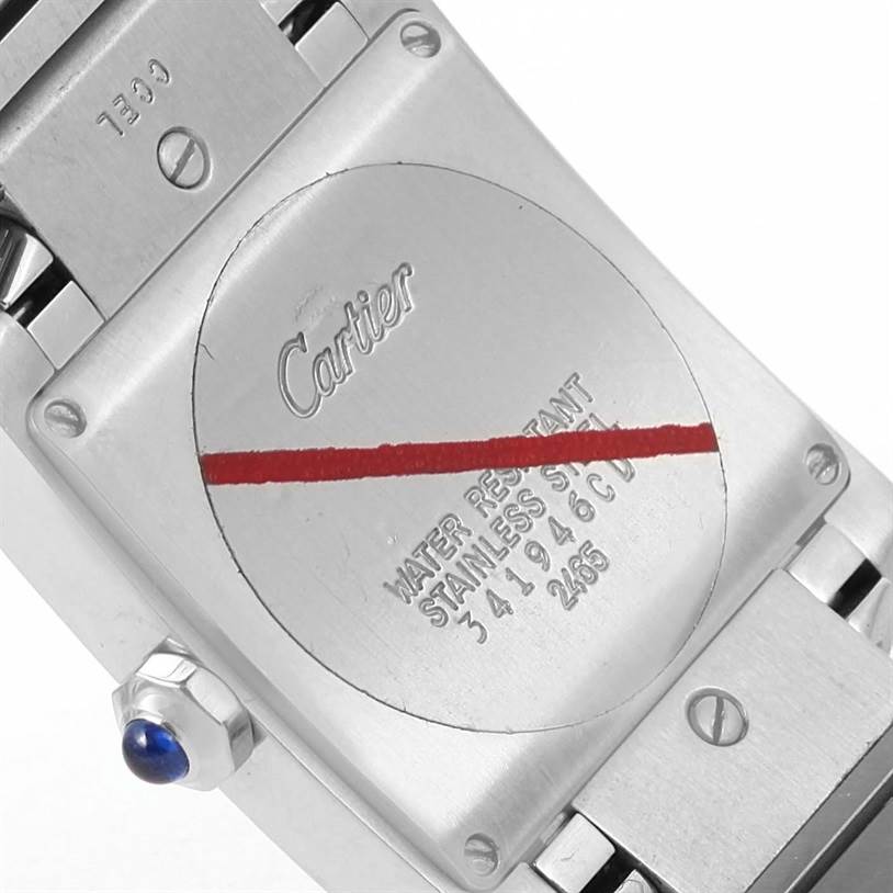 The image shows the back case of a Cartier Tank Française watch, focusing on its engraved details and screws.