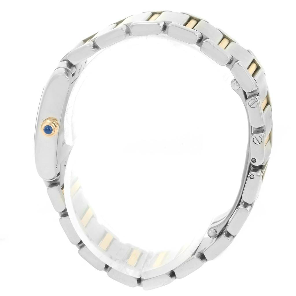 The image shows the side view of a Cartier Tank Française watch, highlighting its metal band and crown with a blue gem.