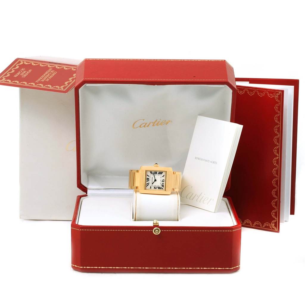 The image shows a Cartier Tank Française watch from a front angle, placed in an open red luxurious box with accompanying booklets.