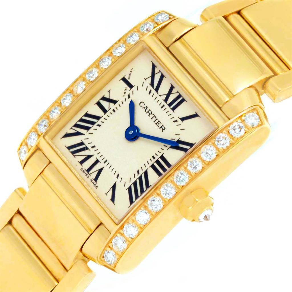 The image shows a close-up, angled view of a Cartier Tank Francaise WE1001R8 Women's Yellow Gold Silver Dial WE1001R8 Women's Yellow Gold Silver Dial watch, highlighting its diamond-studded bezel and gold strap.