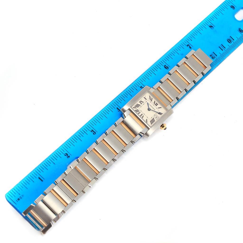 The Cartier Tank Francaise W51012Q4 Women's Steel and Gold (two tone) Silver Dial W51012Q4 Women's Steel and Gold (two tone) Silver Dial watch is shown from a top-down angle, placed alongside a blue ruler.