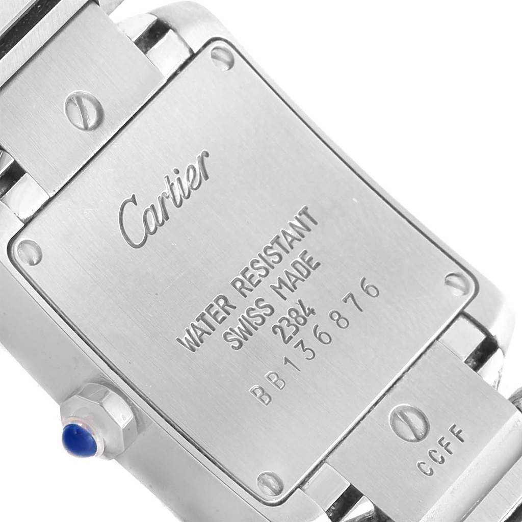 This image shows the backplate and part of the bracelet of a Cartier Tank Francaise W51008Q3 Women's Stainless Steel Silver Dial W51008Q3 Women's Stainless Steel Silver Dial watch with visible inscriptions and screws.