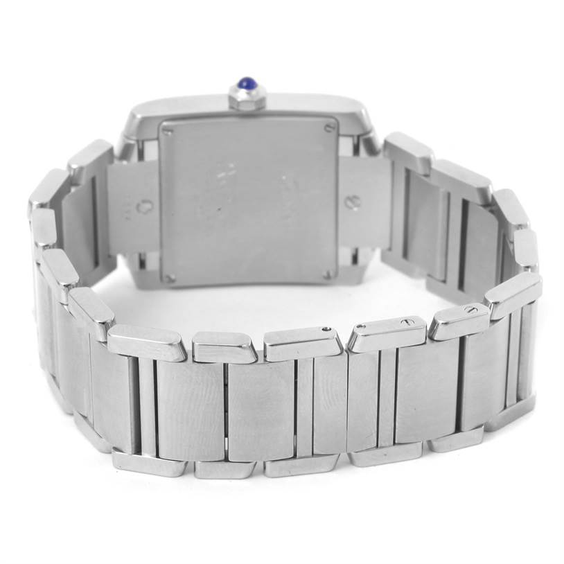The image shows the back view of a Cartier Tank Française watch, highlighting its stainless steel bracelet and case back.