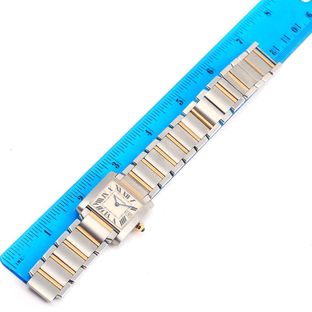 The Cartier Tank Francaise W51012Q4 Women's Steel and Gold (two tone) Silver Dial W51012Q4 Women's Steel and Gold (two tone) Silver Dial watch is shown laid flat next to a blue ruler, with the face and bracelet visible.