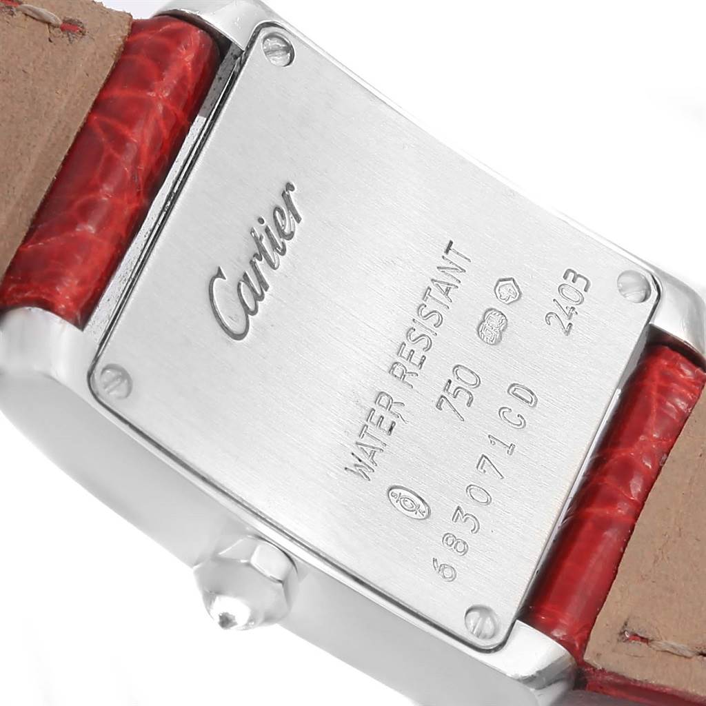 The image shows the back case and part of the leather strap of a Cartier Tank Française watch, highlighting the brand's engraving.