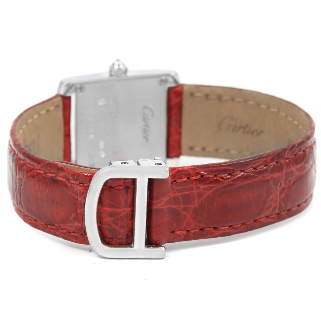 The image shows the back view of a Cartier Tank Francaise WE100231 Women's White Gold Silver Dial WE100231 Women's White Gold Silver Dial watch featuring a red leather strap and a metal clasp.