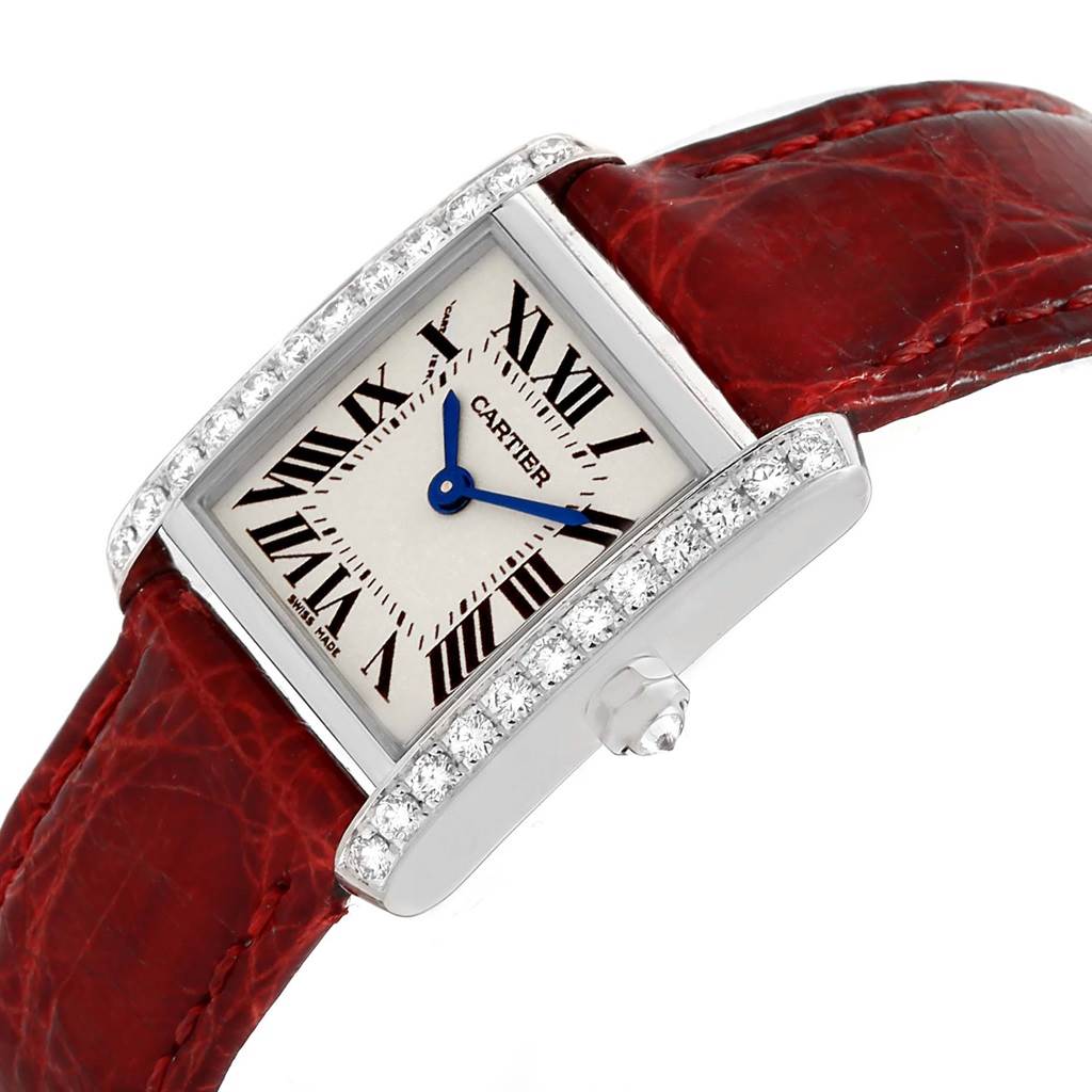 The image shows a Cartier Tank Francaise WE100231 Women's White Gold Silver Dial WE100231 Women's White Gold Silver Dial watch from an oblique angle, highlighting its face, diamond bezel, and red leather strap.