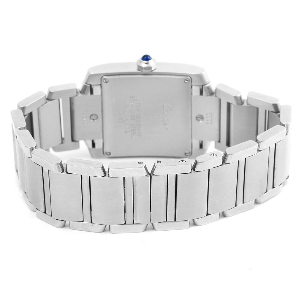 The image shows the back view of the Tank Française watch by Cartier, highlighting the stainless steel case and bracelet.