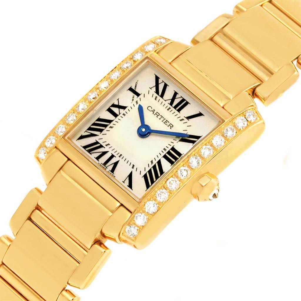 The image shows a close-up of a Cartier Tank Française watch, featuring its gold case, diamond bezel, and bracelet.