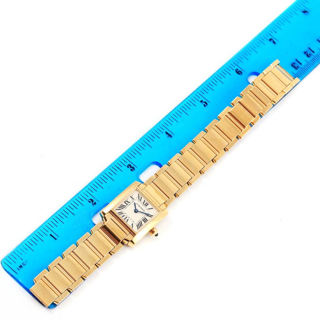 The image shows the entire Cartier Tank Francaise W50002N2 Women's Yellow Gold Silver Dial W50002N2 Women's Yellow Gold Silver Dial watch, including its bracelet, measured against a blue ruler.