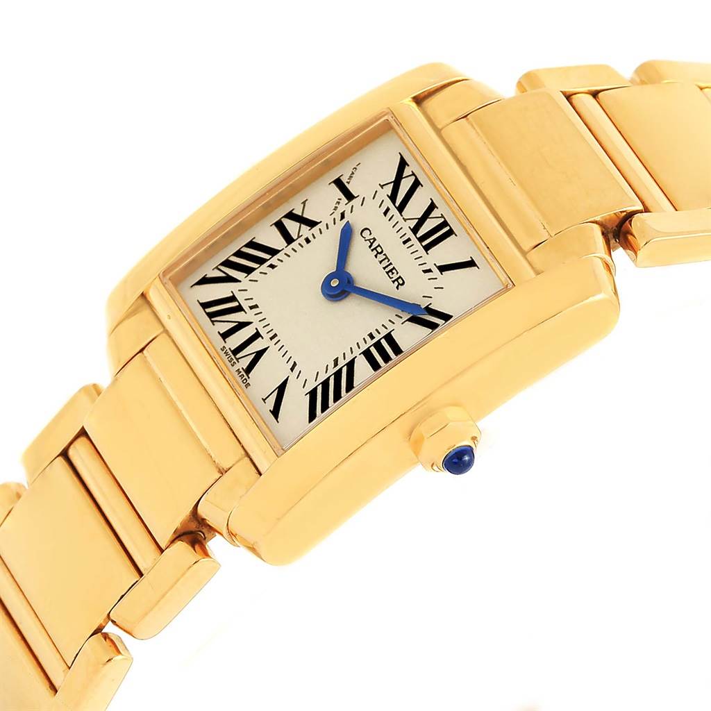 The image shows a Cartier Tank Française watch at an angle displaying its gold case, Roman numeral dial, blue hands, and matching gold bracelet.
