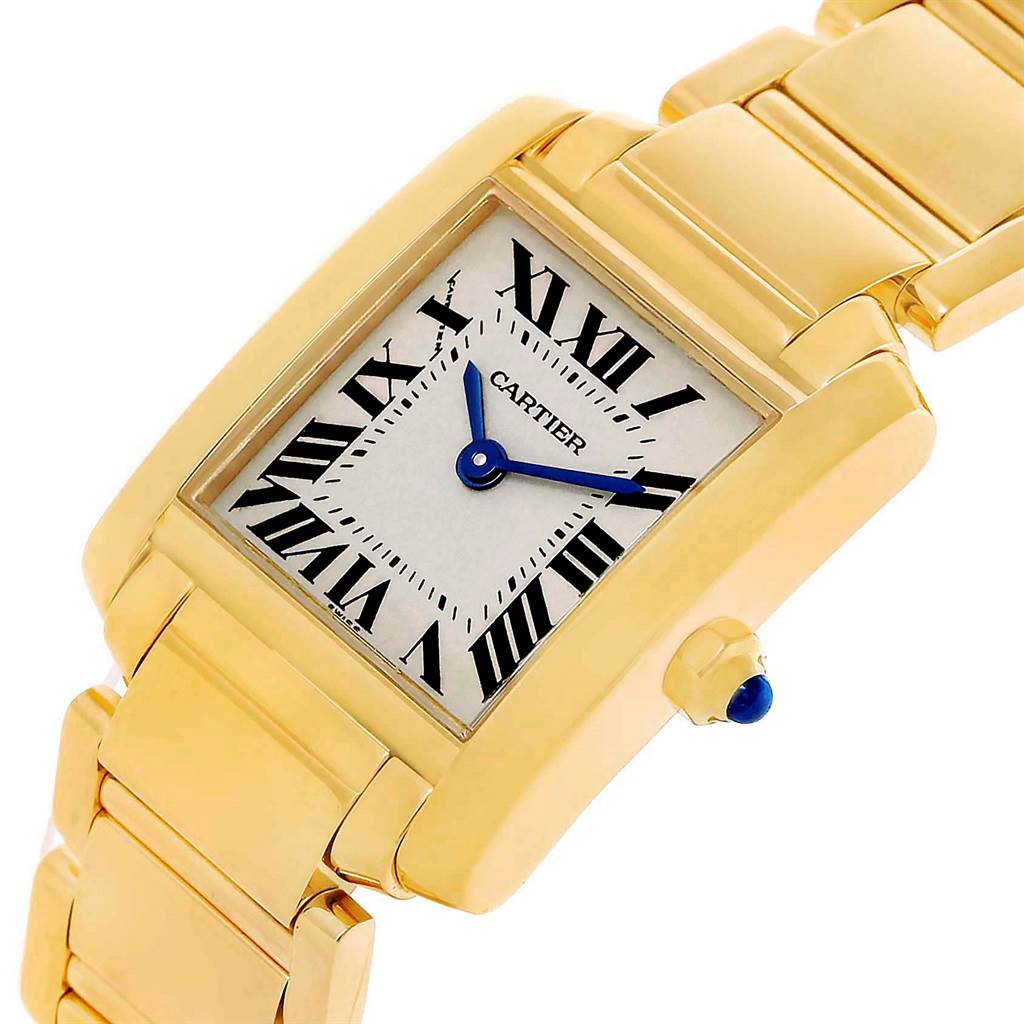 The image shows a close-up angle of a gold Cartier Tank Francaise W50002N2 Women's Yellow Gold Silver Dial W50002N2 Women's Yellow Gold Silver Dial watch, highlighting its face, bracelet, and blue cabochon crown.