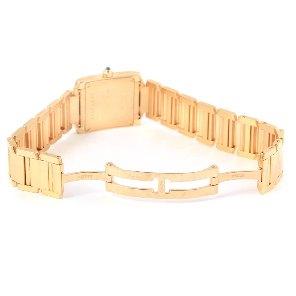 The image shows the back view of a Cartier Tank Francaise W50002N2 Women's Yellow Gold Silver Dial W50002N2 Women's Yellow Gold Silver Dial watch focusing on the open gold metal bracelet and clasp.