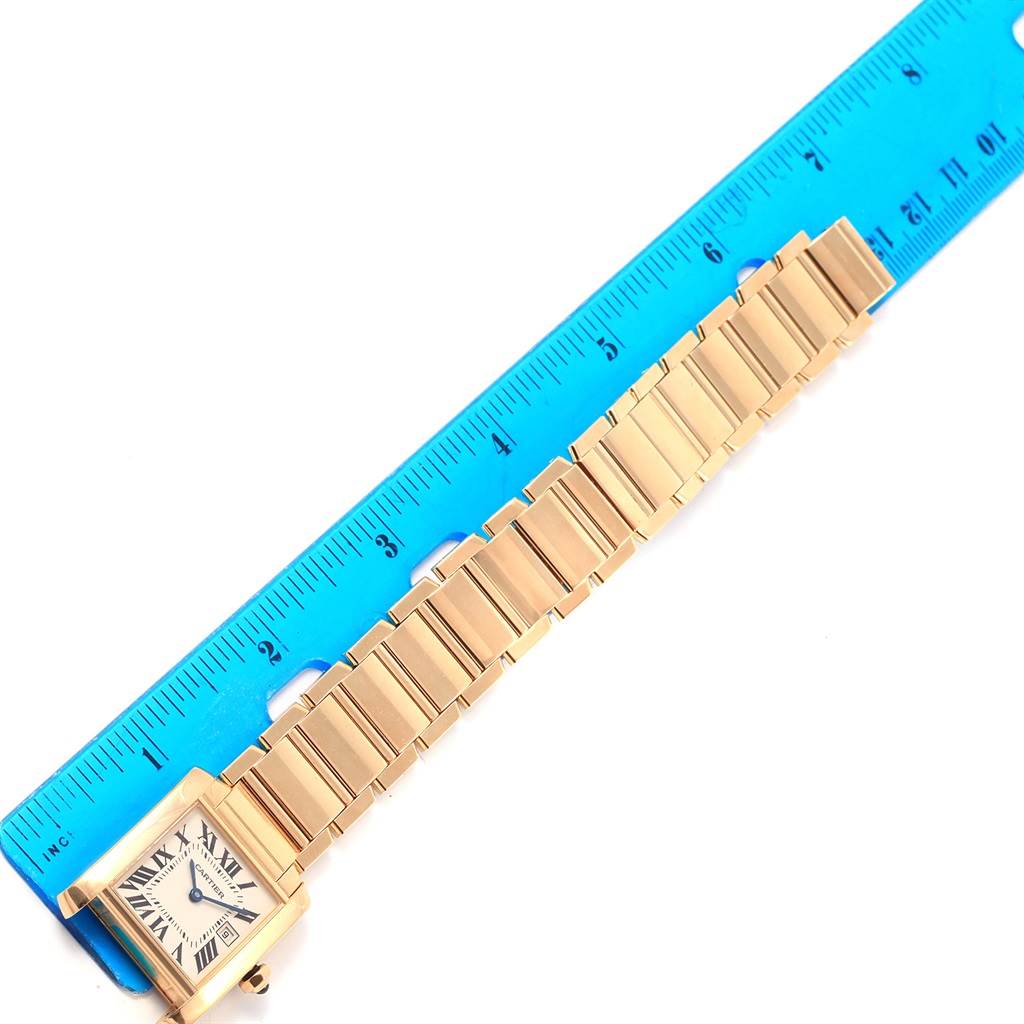 The image shows a Cartier Tank Francaise W50014N2 Women's Yellow Gold Silver Dial W50014N2 Women's Yellow Gold Silver Dial watch laid flat beside a blue ruler for scale.