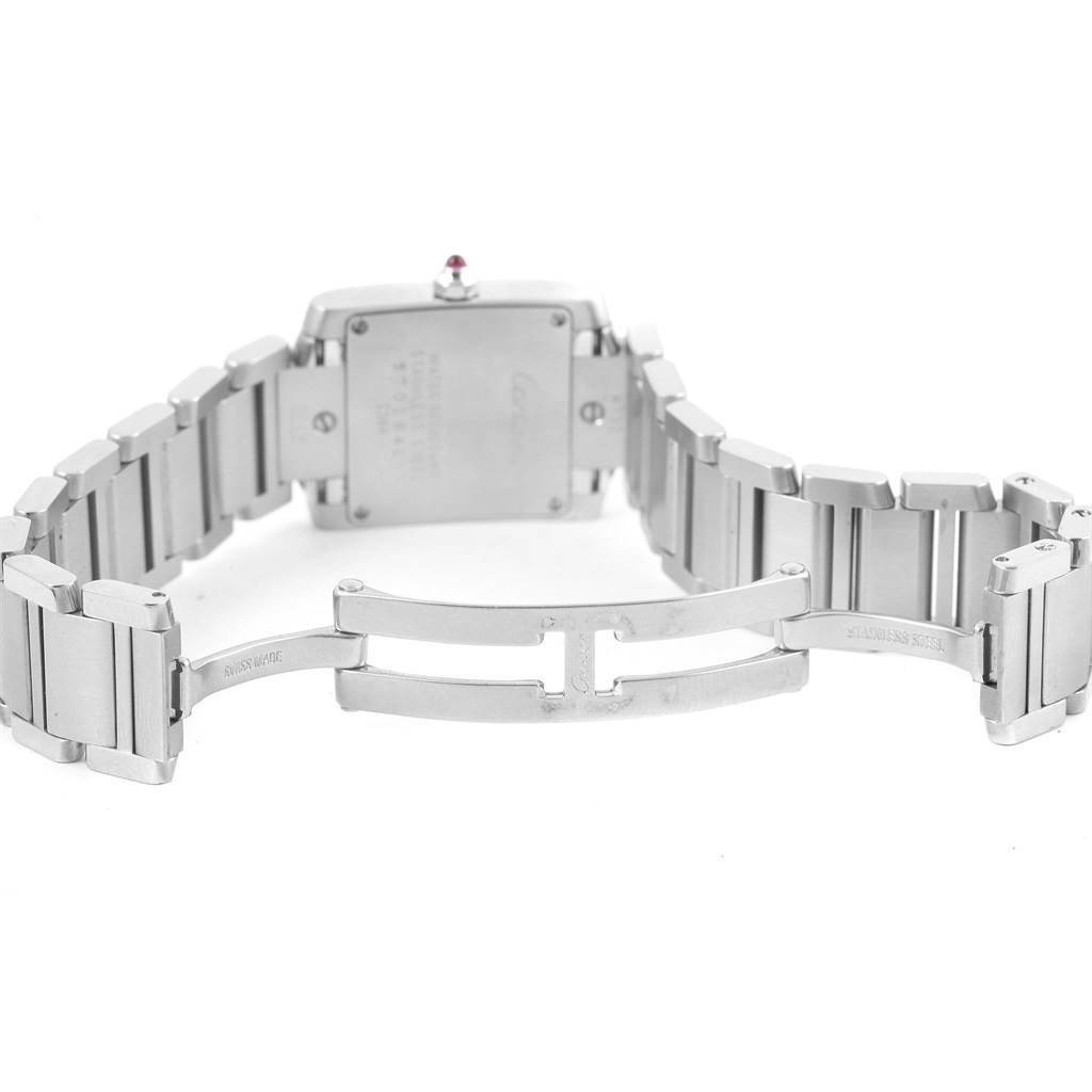 The image shows the underside of the Tank Francaise model by Cartier, highlighting the case back and opened bracelet clasp.