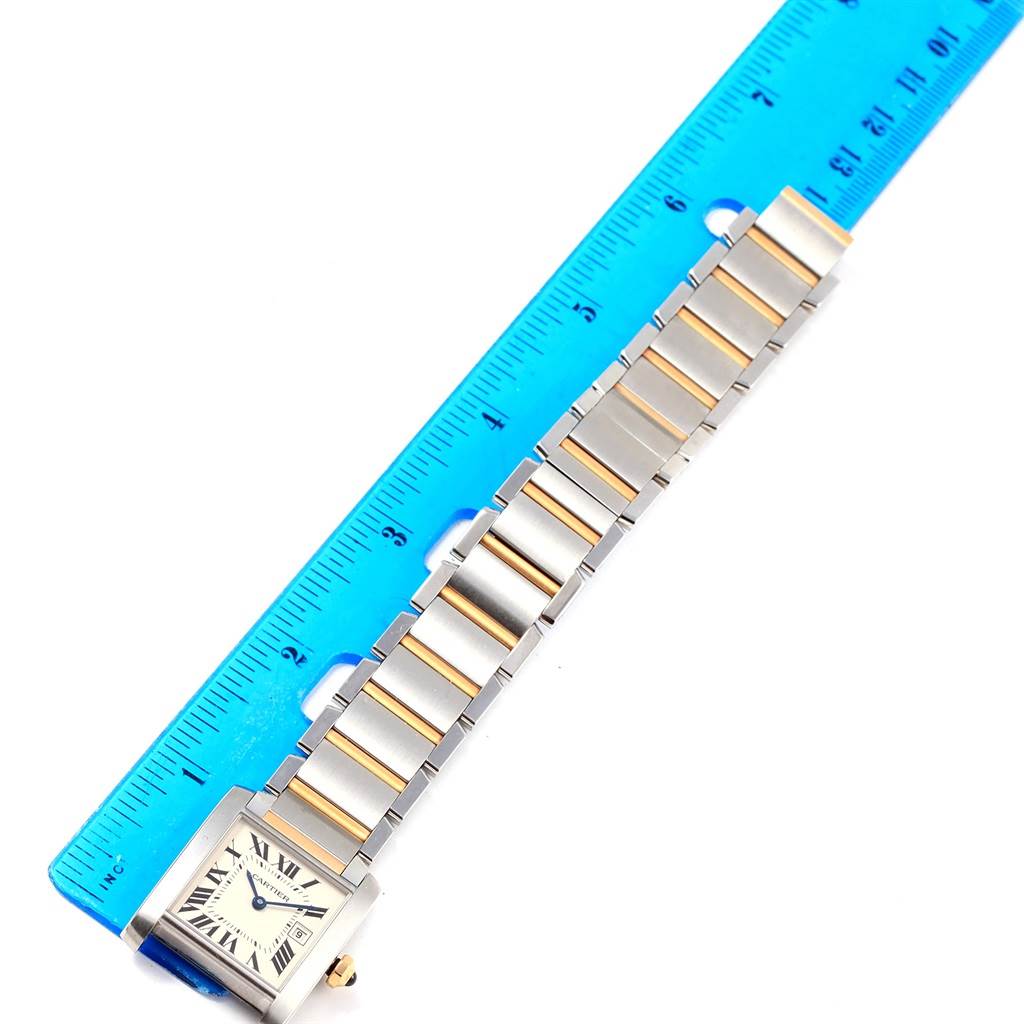 The image shows a top-down view of a Cartier Tank Francaise W51012Q4 Women's Steel and Gold (two tone) Silver Dial W51012Q4 Women's Steel and Gold (two tone) Silver Dial watch next to a blue ruler, displaying the watch band and face.
