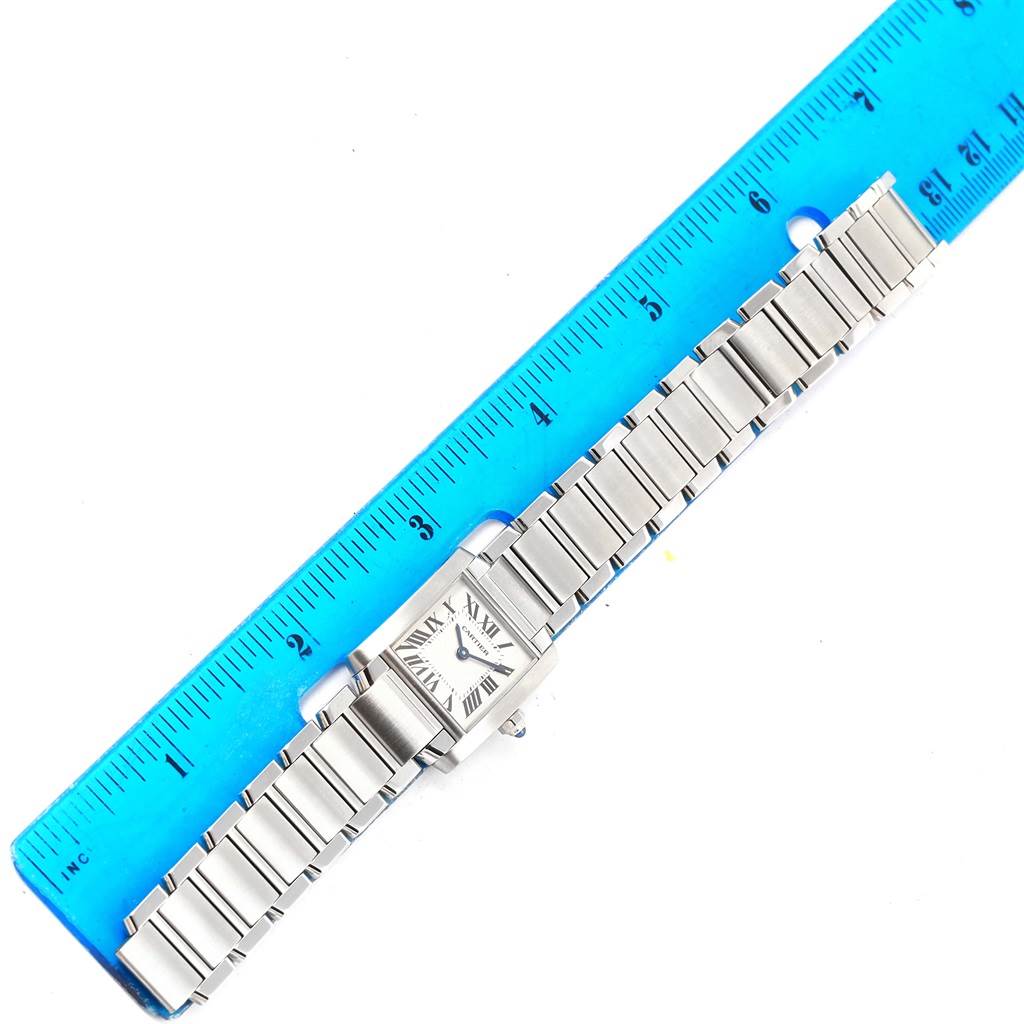 The Cartier Tank Francaise W51008Q3 Women's Stainless Steel Silver Dial W51008Q3 Women's Stainless Steel Silver Dial watch is shown horizontally with its metal bracelet alongside a blue ruler for measurement.