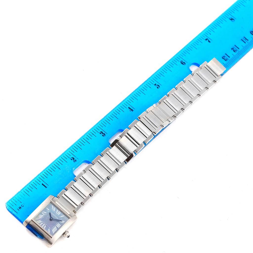 The image shows a Cartier Tank Francaise W51034Q3 Women's Stainless Steel Mother of Pearl Dial W51034Q3 Women's Stainless Steel Mother of Pearl Dial watch laying flat next to a ruler, displaying its rectangular face and metal bracelet.