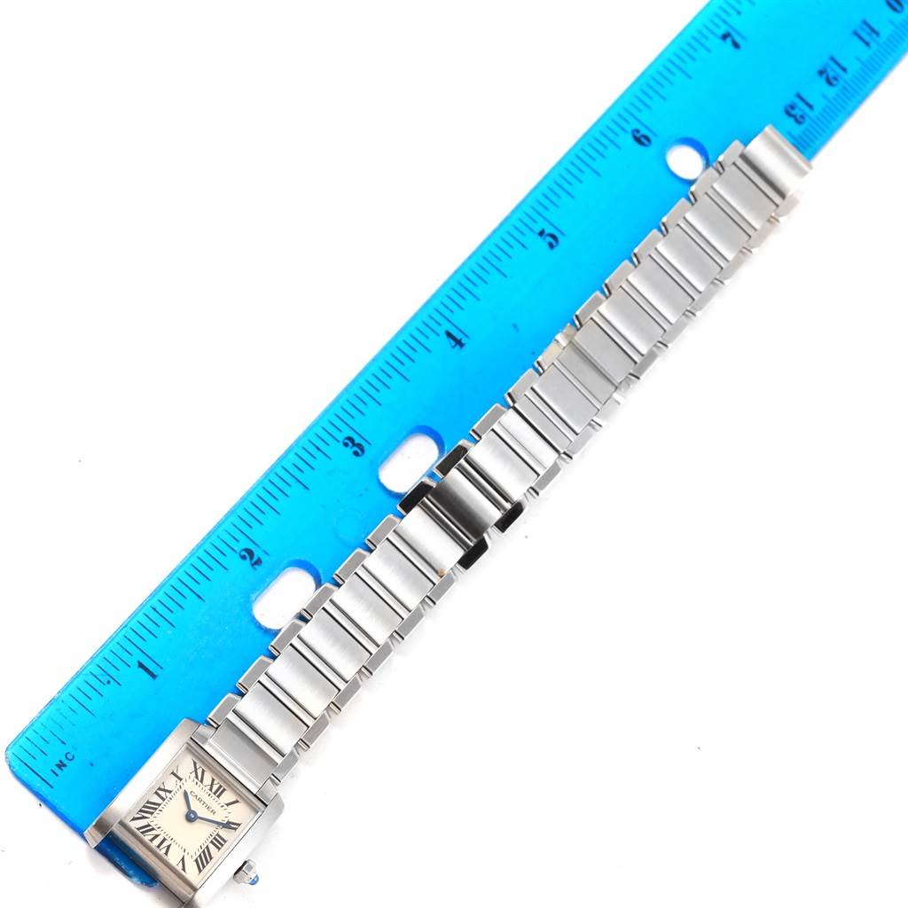 The image shows a Cartier Tank Française watch laid flat with its band fully extended, next to a ruler for scale.