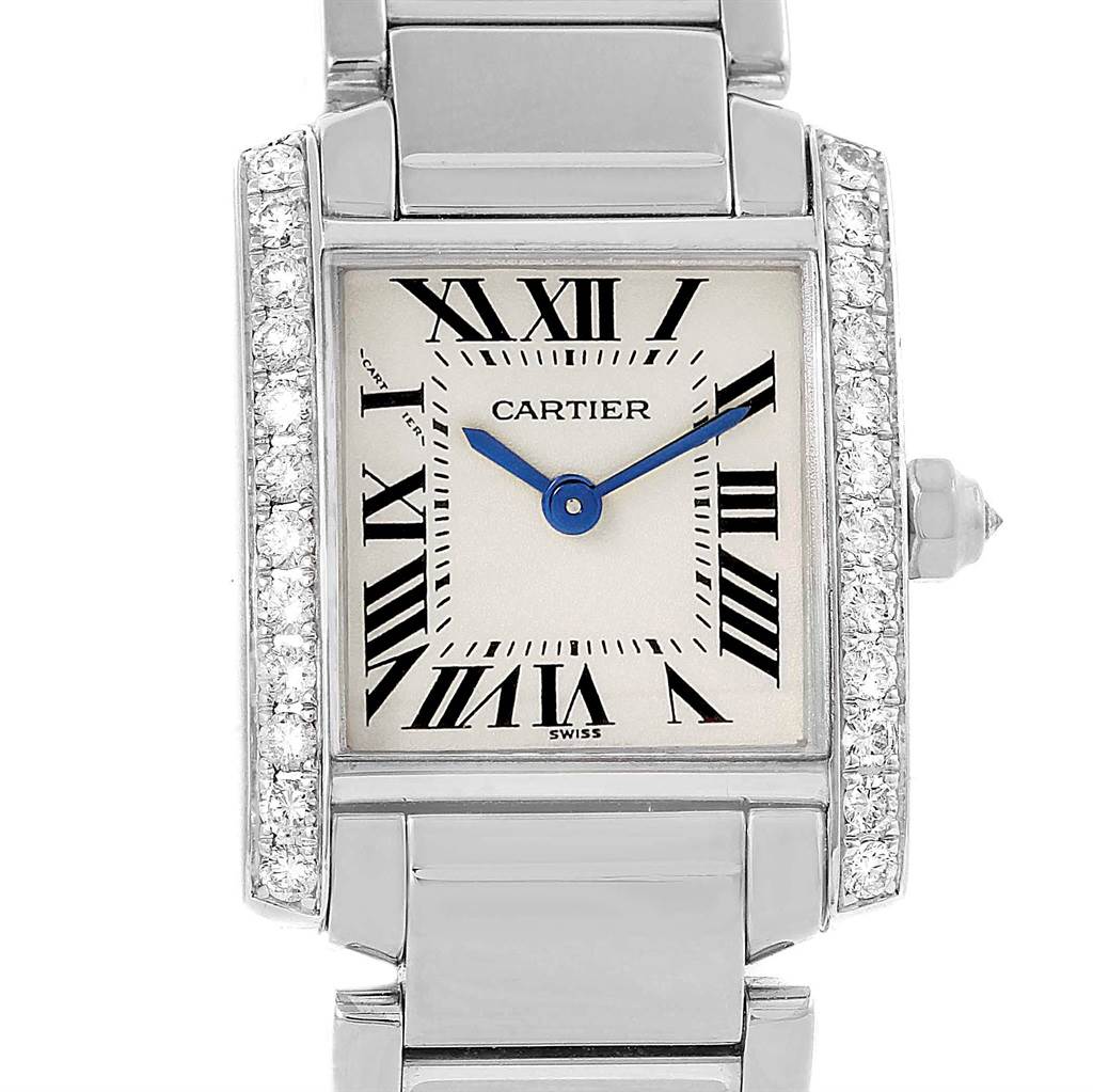 This is a close-up view of a Cartier Tank Française watch, showing the face with Roman numerals, blue hands, and metal band.