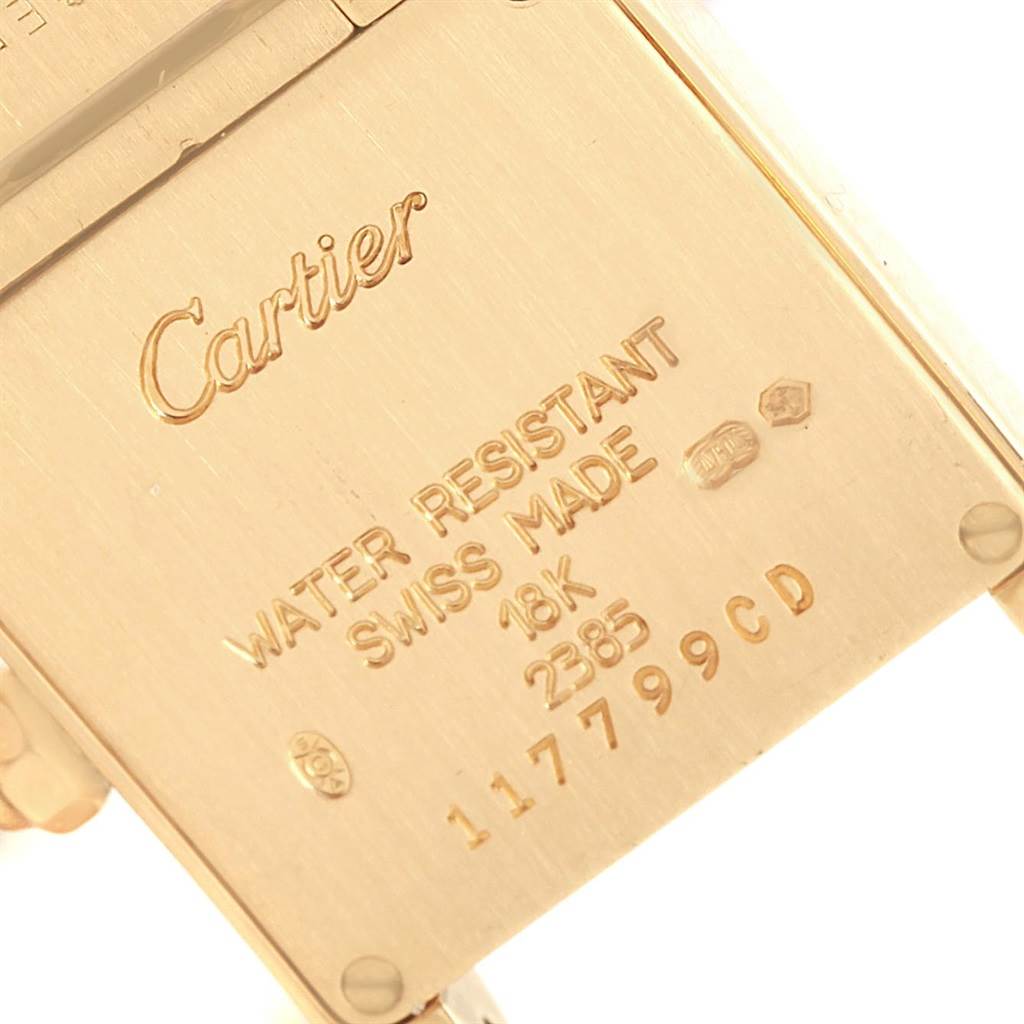 This image shows a close-up of the back of a Cartier Tank Française watch, highlighting brand engravings and specifications.