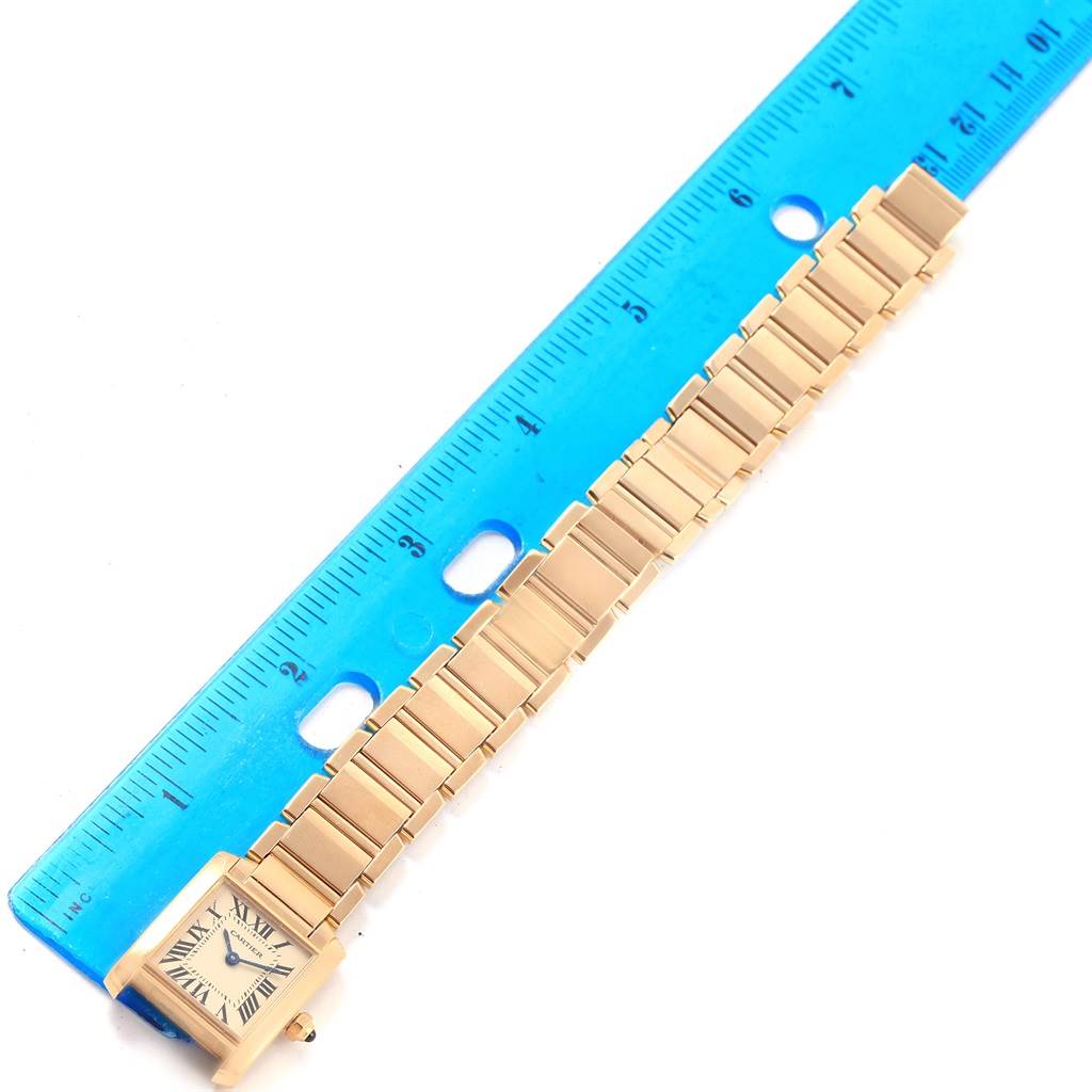 This image shows the Cartier Tank Francaise W50002N2 Women's Yellow Gold Silver Dial W50002N2 Women's Yellow Gold Silver Dial watch horizontally, alongside a ruler for scale.