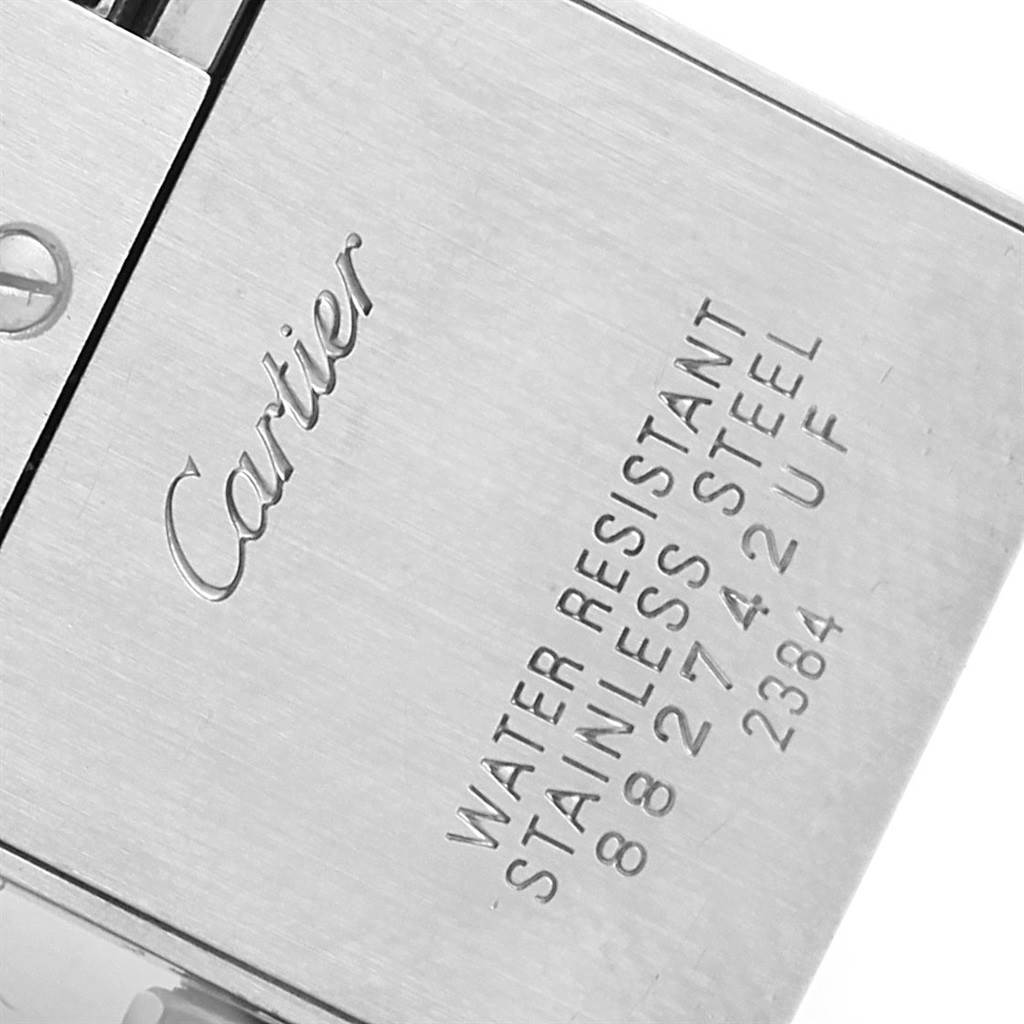 The image shows a close-up of the back case of a Cartier Tank Française watch with engraved details.