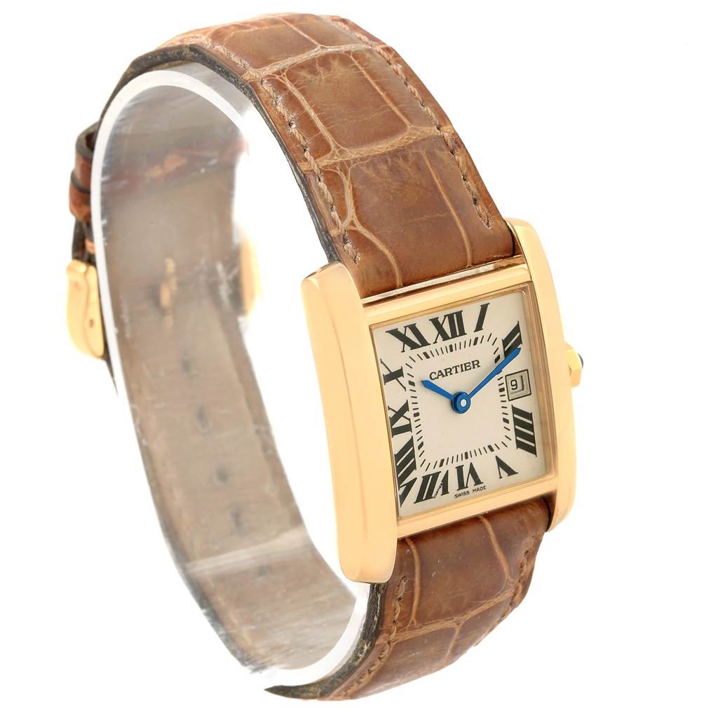 The Cartier Tank Francaise W50014N2 Women's Yellow Gold Silver Dial W50014N2 Women's Yellow Gold Silver Dial watch is shown at an angle highlighting its face, leather strap, and gold casing.