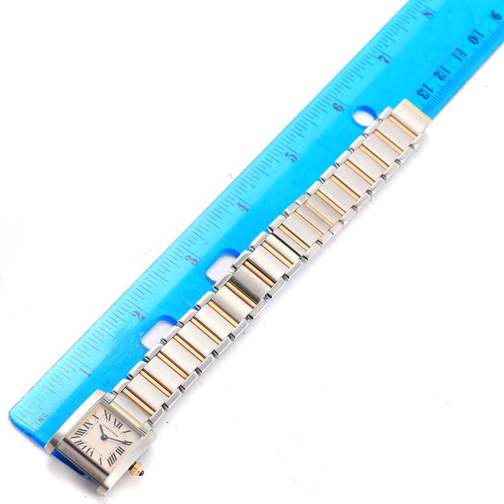 The image shows a Cartier Tank Francaise W51007Q4 Women's Steel and Gold (two tone) Silver Dial W51007Q4 Women's Steel and Gold (two tone) Silver Dial watch, lying flat next to a blue ruler, displaying its band and watch face.