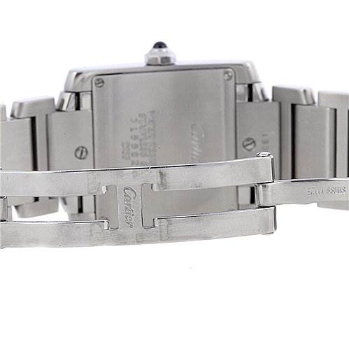 The image shows the back case and bracelet clasp of a Cartier Tank Française watch, focusing on its stainless steel components and engravings.