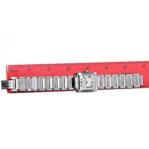 The Cartier Tank Française watch is shown from a top-down angle with its entire stainless steel bracelet and face visible alongside a red ruler.