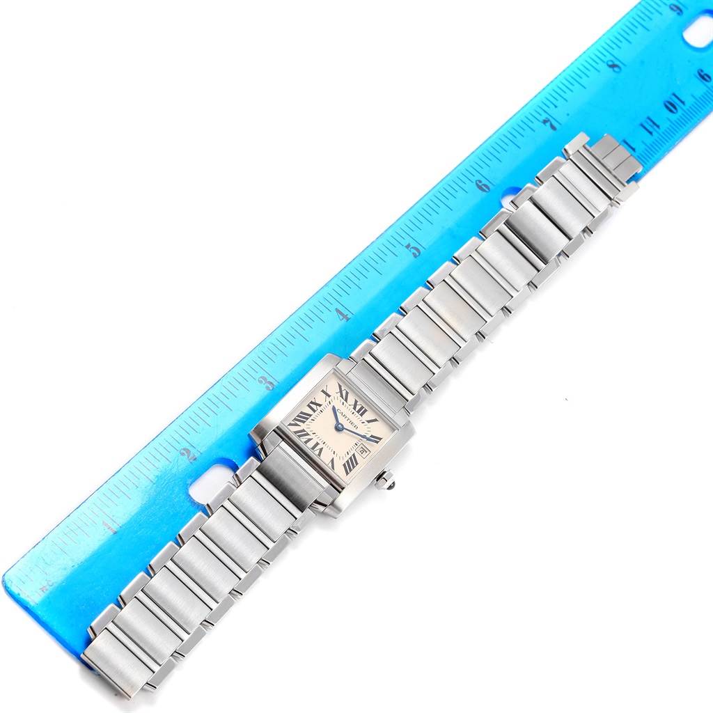 The image shows a Cartier Tank Francaise W51011Q3 Women's Stainless Steel Silver Dial W51011Q3 Women's Stainless Steel Silver Dial watch laid flat next to a blue ruler, displaying its face and metal bracelet band.