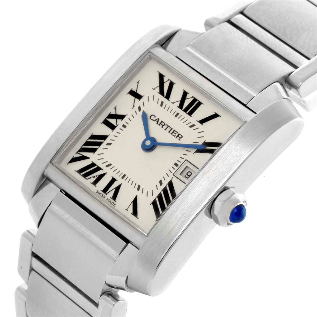 The image shows a close-up of a Cartier Tank Française watch, highlighting its face, bezel, bracelet, and crown with a blue cabochon.