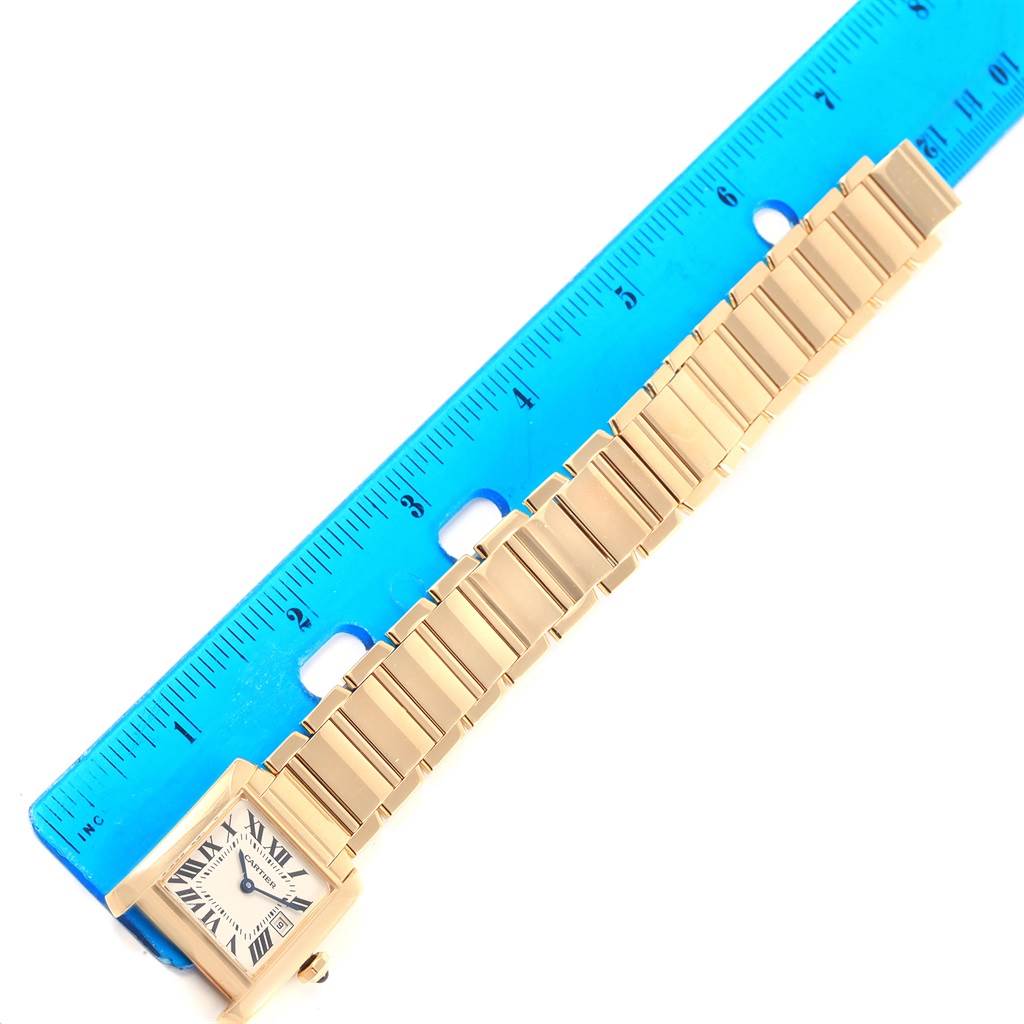 The Cartier Tank Francaise W50014N2 Women's Yellow Gold Silver Dial W50014N2 Women's Yellow Gold Silver Dial watch is shown from the top view, featuring its rectangular dial and linked bracelet, alongside a ruler for scale.