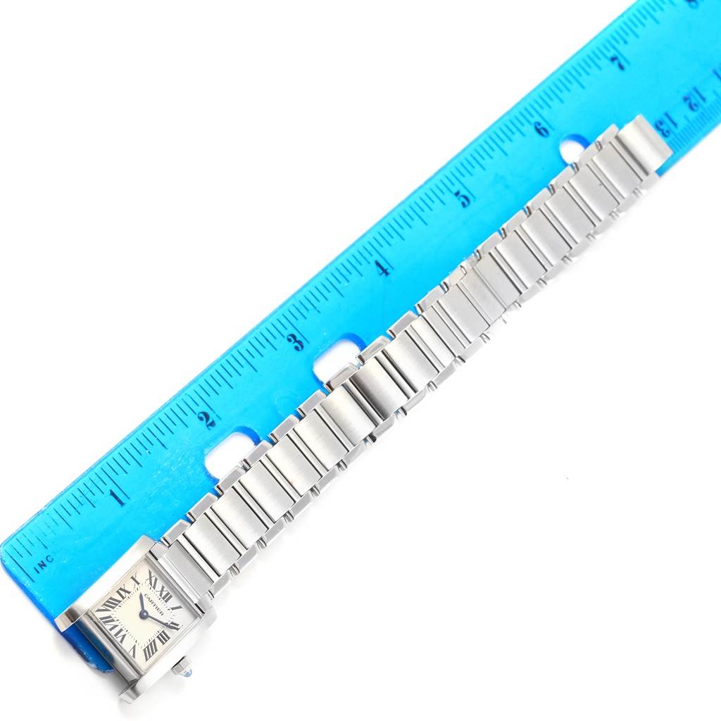 The Cartier Tank Francaise W51008Q3 Women's Stainless Steel Silver Dial W51008Q3 Women's Stainless Steel Silver Dial watch is shown from a top-down angle, displaying its face, bracelet, and a blue ruler for scale.