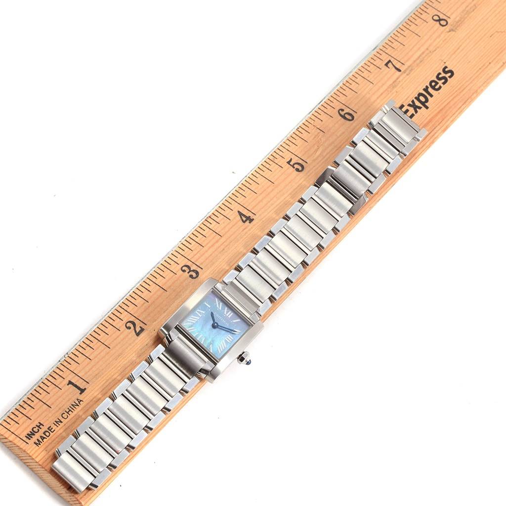 The Tank Française model by Cartier is shown from a top-down angle, displaying the face and the full metal bracelet against a ruler.